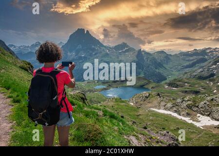 Wanderfrau, die ein Foto von Pic du Midi Ossau in den französischen Pyrenäen gemacht hat Stockfoto