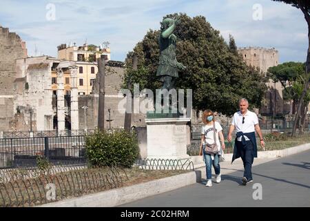 Menschen mit Schutzmaske gehen am 02. Juni 2020 entlang der Via dei Fori Imperiali im Zentrum Roms, als Italien beginnt, seine Sperre zu lockern, während das Land die Ausbreitung der COVID-19-Infektion, die durch das neuartige Coronavirus verursacht wird, eindämmen will. Stockfoto