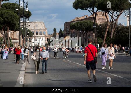 Menschen mit Schutzmaske gehen am 02. Juni 2020 entlang der Via dei Fori Imperiali im Zentrum Roms, als Italien beginnt, seine Sperre zu lockern, während das Land die Ausbreitung der COVID-19-Infektion, die durch das neuartige Coronavirus verursacht wird, eindämmen will. Stockfoto