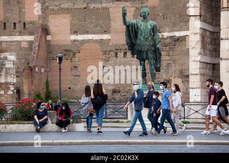 Menschen mit Schutzmaske gehen am 02. Juni 2020 entlang der Via dei Fori Imperiali im Zentrum Roms, als Italien beginnt, seine Sperre zu lockern, während das Land die Ausbreitung der COVID-19-Infektion, die durch das neuartige Coronavirus verursacht wird, eindämmen will. Stockfoto