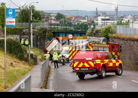 Cork, Irland. Juni 2020. LKW stürzt in Bridge, Blackpool, Cork City. Kurz vor 10 Uhr heute wurden Rettungsdienste vor Ort ein Vorfall gerufen, bei dem ein Gelenkwagen mit einer Eisenbahnbrücke auf Dublin Hill kollidierte. Der Stapler drehte sich auf seine Seite, als er in die Brücke stürzte. Es gibt Berichte, dass es keine Verletzungen gibt. Die Einsatzkräfte sind noch immer am Einsatzort. Im Verkehrsbereich werden erhebliche Verzögerungen mit der Schließung der Straße und mögliche Zugverzögerungen bis zur Überprüfung der Brücke zu beobachten sein. Kredit: Damian Coleman / Alamy Live News Stockfoto