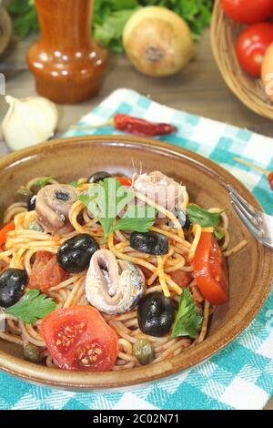 Spaghetti alla puttanesca mit Oliven und Sardelle Stockfoto