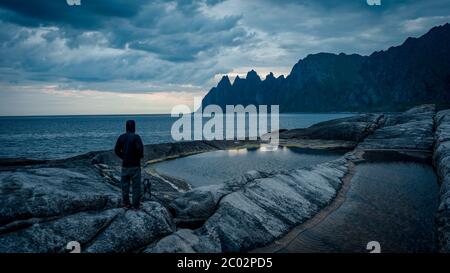 Der Fotograf blickt in die Landschaft und lauscht der Stille. Mann bereiten Kamera, um beeindruckende Fotos von nebligen Herbst Berge. Stockfoto