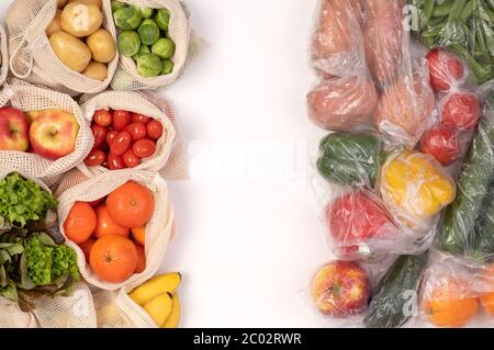 Keine Abfälle im Vergleich zu Kunststoffverpackungen. Obst und Gemüse in umweltfreundlichen wiederverwendbaren Baumwollbeuteln und in Plastiktüten, Draufsicht Stockfoto