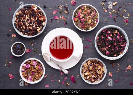 Tasse Früchtetee auf dunklem, steinernem Hintergrund, Draufsicht Stockfoto