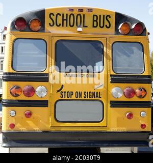 Rückansicht eines traditionellen gelben Schulbusses auf der Straße Stockfoto