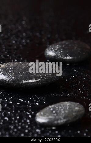 Schwarze Spa-Steine mit Wassertropfen Stockfoto