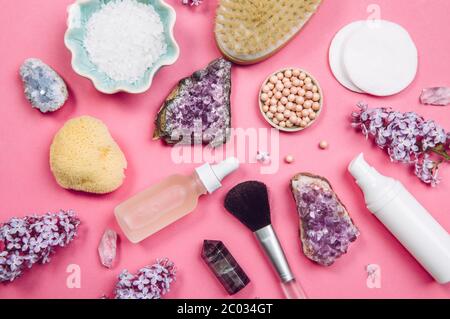 Oben von oben nach unten Ansicht von verschiedenen weißen Kosmetik- und Beauty-Produkte Behälter mit Flieder (Syringa) Blüten und halb kostbaren Amethyst Kristall Cluster Stockfoto