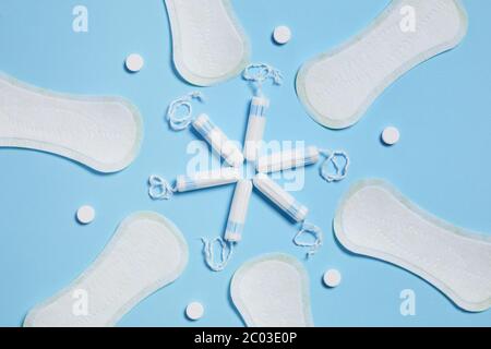 Muster mit weißen Damenbinden und Tampons auf blauem Hintergrund. Feminine Hygieneprodukte Stockfoto