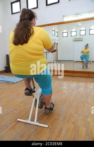 übergewichtige Frau auf Fahrrad Simulator Training Stockfoto