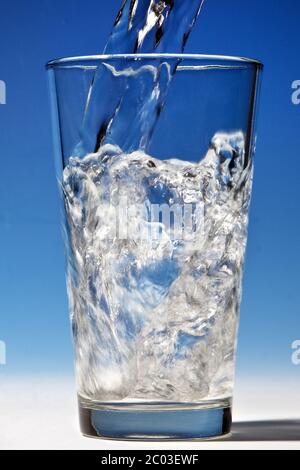 Wasser wird in ein Glas gegossen werden Stockfoto