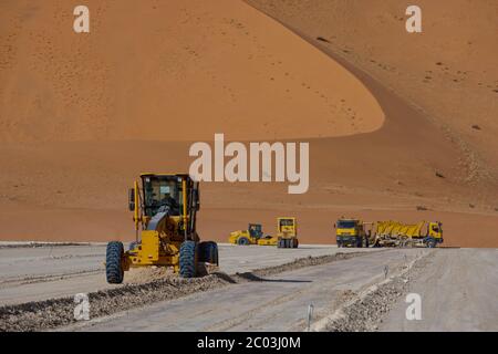 Schwere Ausrüstung, die Gips ausstreut, um eine Grundlage für eine Ölanlage in der Sahara zu bilden. Stockfoto