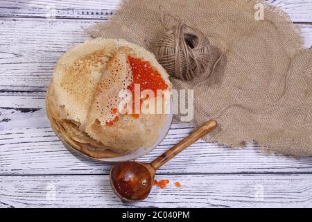Pfannkuchen mit rotem Kaviar und einem Holzlöffel Stockfoto