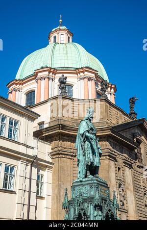 Statue von König Karl IV. Am Turm der Karlsbrücke und der Kirche des Heiligen Franz von Assissi in Prag, Tschechien, Details, blauer Himmel Stockfoto