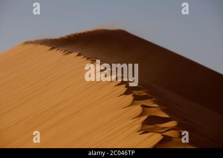 Fußabdrücke am Rande einer großen Düne Sanddünen in der Sahara, Nordafrika. Stockfoto