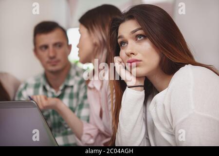 Überbelasten, Langeweile Konzept. In der Nähe von einem schönen weiblichen Studenten im Unterricht gelangweilt. Attraktive junge Frau student abgenutzt Stockfoto