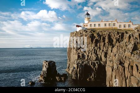 Der Leuchtturm Neist Point am Ende der Welt. Schaumig blaues Meer trifft auf die scharfe Klippe. Die Isle of Skye, Schottland Stockfoto
