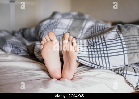 Füße eines Jungen im Bett liegend. Stockfoto
