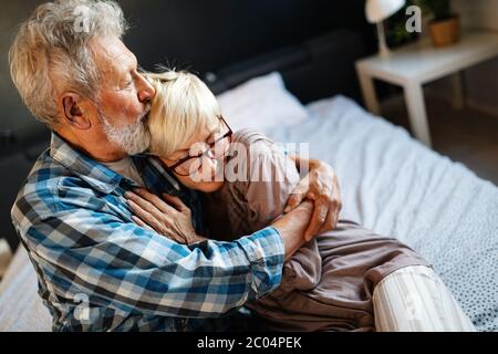 Gerne älteres Paar in Liebe umarmen und Verklebung mit Emotionen zu Hause Stockfoto