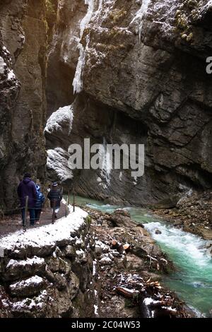 Garmisch-Partenkirchen - 20. Februar 2020: Touristen in schneebedeckten Eiszapfen am berühmten Touristenziel Partnachklamm. Partnachklamm in G. Stockfoto