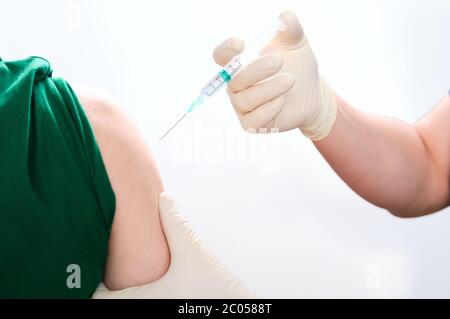 Nicht erkennbare Krankenschwester, die einen Patienten impft. Coronavirus-Impfstoff-Konzept. Stockfoto