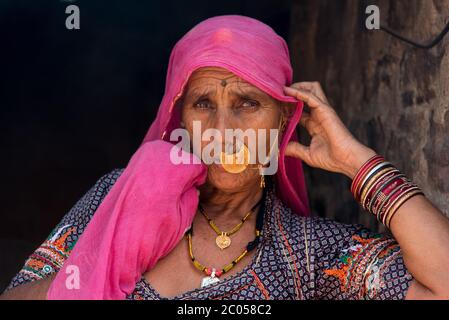 Eine indische Frau, die traditionell in ihrem Zuhause in einem Dorf in Rajasthan, Indien gekleidet ist. Stockfoto