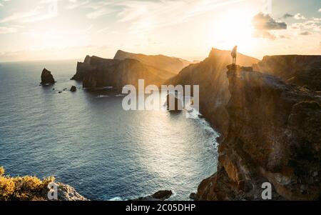 Reisen Mann allein auf der Klippe Blick auf das Meer, Wandern Abenteuer Lifestyle extreme Ferien Sonnenuntergangslandschaft in Portugal, Madeira Stockfoto