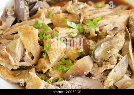 Gekochte Ente in brauner Suppenscheibe und Topping Frühlingszwiebel auf Teller hacken Stockfoto