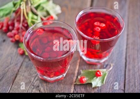 Viburnum Getränk im Glas und auf einem Tisch Stockfoto