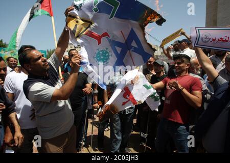 Rafah, Gaza. Juni 2020. Palästinenser verbrennen ein Banner mit einer israelischen Flagge während eines Protestes gegen Israels Pläne, einen Teil des besetzten Westjordanlandes in Rafah im südlichen Gazastreifen zu annektieren, am Donnerstag, den 11. Juni 2020. Israel hat signalisiert, dass es beabsichtigt, die Siedlungen im Westjordanland und das Jordantal zu annektieren, wobei erste Schritte ab dem 1. Juli geplant sind. Foto von Ismael Mohamad/UPI Quelle: UPI/Alamy Live News Stockfoto