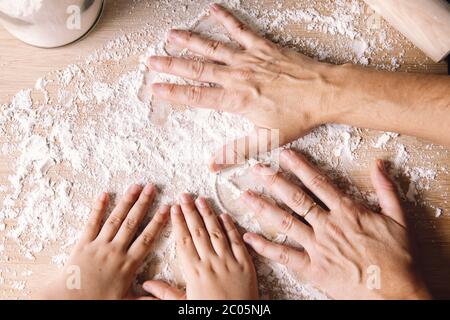 Mutter und Tochter Hände setzen Mehl auf den Küchentisch, Konzept der gesunden Ernährung zu Hause Stockfoto