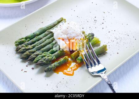 Frisch geschnittenen gekochten Grünspargel mit Spiegeleiern Stockfoto