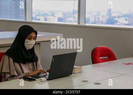 Eine Frau arbeitet mit einem Laptop an der Nationalbibliothek der Republik Indonesien während der Covid-19-Pandemie in Jakarta, Indonesien, 11. Juni 2020. (Foto von Muhammad Rifqi Riyanto / INA Photo Agency / Sipa USA) Stockfoto