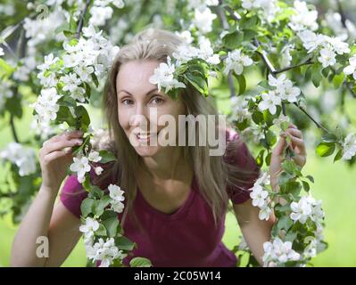 Frau stand in der Nähe des blühenden Apfelbaums. Stockfoto