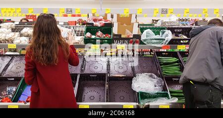 Fast vollständig leere Gemüseregale in einem riesigen Lebensmittelgeschäft aufgrund von Panik und Angst im Zusammenhang mit dem Ausbruch des COVID-19 Coronavirus in Europa Stockfoto