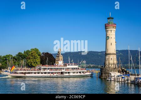 Ausflugsschiff verlässt den Hafen, Leuchtturm Neu Lindau und den bayerischen Löwen im Hafen auf der Insel, Insel Lindau, Lindau am Bodensee, Stockfoto