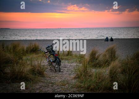 Fahrräder und Paar am Strand von Amager bei Sonnenaufgang, Kopenhagen, Dänemark Stockfoto