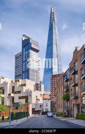 Die imposanten Türme des Guys Hospital (links) und des Shard (rechts) von einer nahe gelegenen Wohnstraße in Bermondsey, Süd-London. Stockfoto