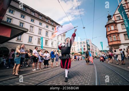 Fahnenschwänger der traditionellen Volksmusik- und Künstlergruppe Trääs aus Sulzbach Murr werfen während der Kiliani-Messe-Parade Fahnen in die Luft. Stockfoto