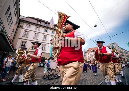 Musiker mit traditionellen deutschen Baritonmessern in typischer roter Tracht bei der Eröffnungsparty der Kiliani Sommermesse in Bayern - Deutschland. Stockfoto