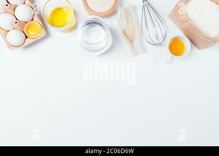 Zutaten für das Backen von hausgemachtem Brot. Bio Vollkornmehl, Hefe, Honig, Wasser und Eier auf weißem Hintergrund mit Kopierraum, flach legen. Stockfoto