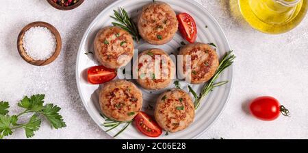 Frische Chiken-Koteletts mit Tomaten und Rosmarin, Draufsicht Stockfoto