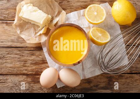 Köstliche Hollandaise-Sauce aus nächster Nähe auf dem Tisch mit Zutaten Eier, Zitrone, Butter. Horizontale Draufsicht von oben Stockfoto