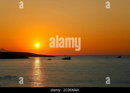 Sonnenuntergang über dem Meer. Drifter Typ (Trawler) kommerzielle Fischerboote vor der Sonne vorbei und auf dem Weg zum Nachtfischen. Old Phocaea, Izmir / Stockfoto