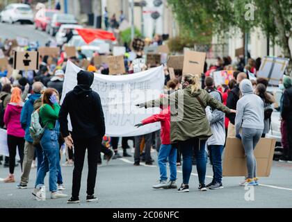 Newport, Wales, Großbritannien. Juni 2020. Die Menschen strecken ihre Arme aus, um während des Black Lives Matter marsches in Newport sozial fern in der Menge zu bleiben. Hunderte von Menschen schlossen sich dem Protest nach dem Tod von George Floyd, einem 46-jährigen, afroamerikanischen Mann, der während einer Verhaftung durch die Minneapolis-Polizei für angeblich mit einer gefälschten Rechnung starb. Sein Tod hat weltweit riesige Proteste gegen Rassendiskriminierung ausgelöst. Kredit: Tracey Paddison/Alamy Live News Stockfoto