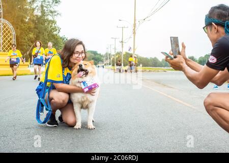Kanchanaburi THAILAND - 6. Oktober: Unidentifizierte Thailänderin mit ihrem Hundelauf und fotografieren auf der Stadtstraße am 6.2019 in Kanchanaburi, Stockfoto