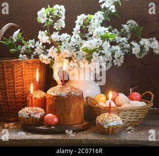 Osterstill-Leben mit einem Frühlingsstrauß, einem Osterkuchen und den bemalten Eiern Stockfoto