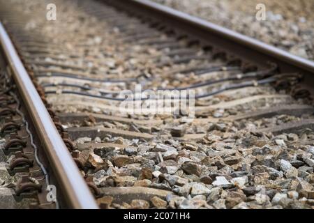 Nahaufnahme auf einem Teil der Eisenbahnstrecke, Fokus auf den Schotter unten. Enge Schärfentiefe Stockfoto