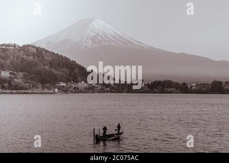 Fischer fischen auf einem kleinen Boot am Kawaguchi See vor dem Fuji Berg Stockfoto
