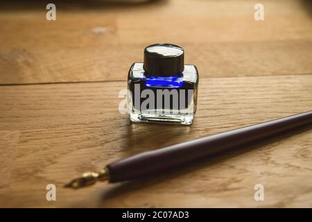 Blaue Tinte und Füllfederhalter auf einem Schreibtisch Stockfoto